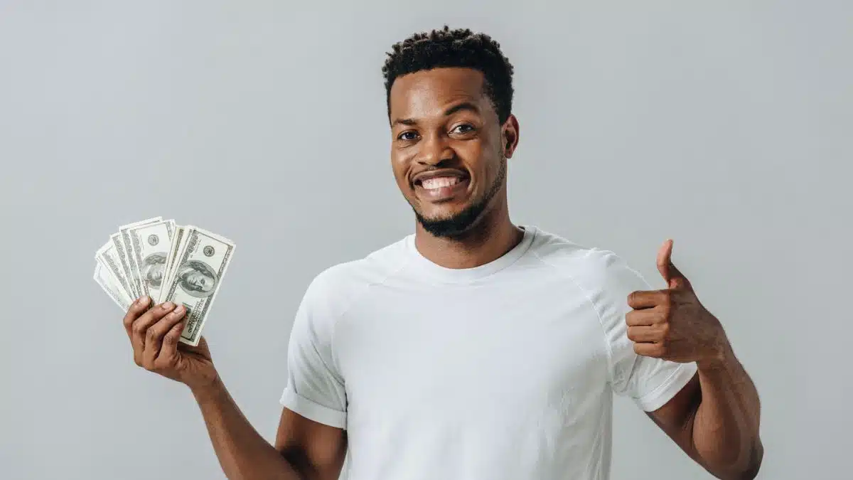 man holding cash and happy