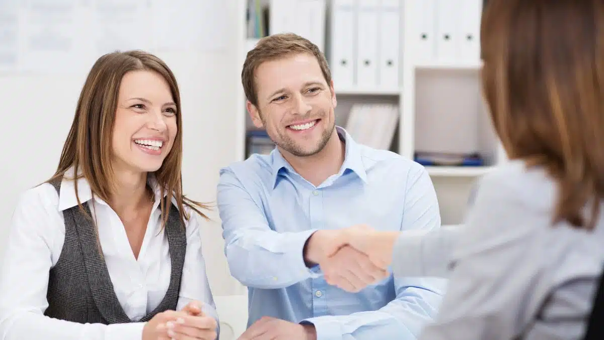 couple shaking hands at a bank