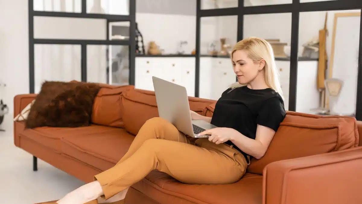 woman sitting on a couch on a laptop