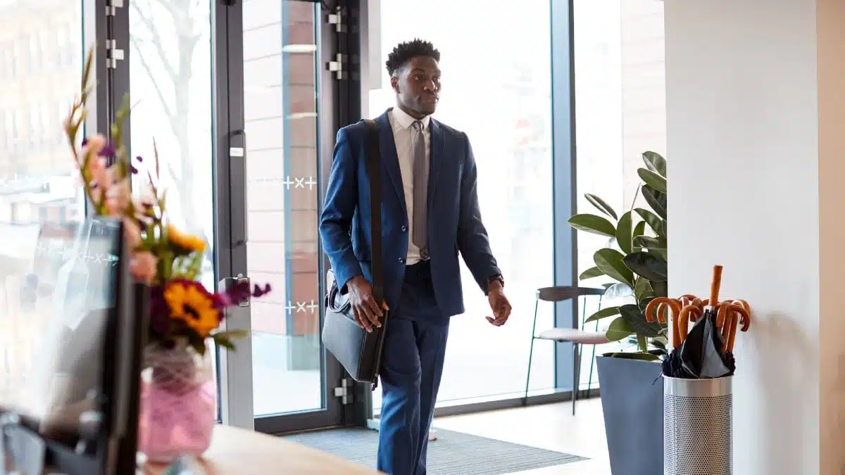 15 Office Rules That Quietly Grow Their Income Businessman-Arriving-For-Work-At-Office-Walking-Through-Door-2