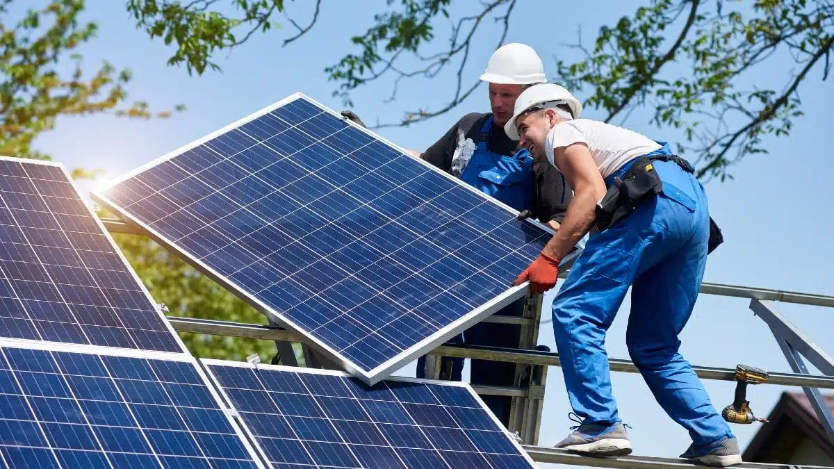 Two-young-technicians-mounting-heavy-solar-photo-voltaic-panel-2