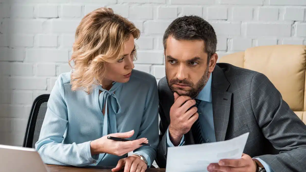 15 Office Rules That Quietly Grow Their Income woman talking to coworker man office